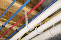 PEX and drain pipe attached to the basement ceiling of a home.