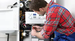 Technician servicing heating boiler