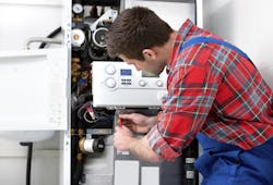 Technician servicing heating boiler Technician servicing heating boiler