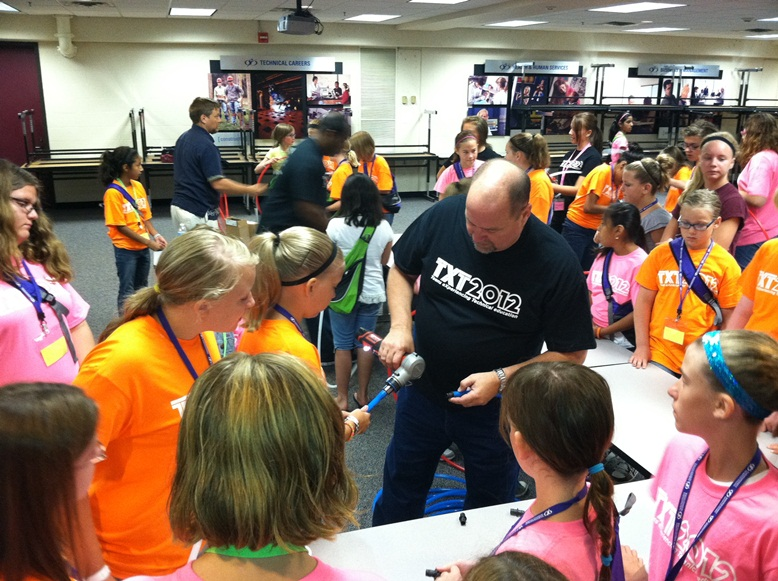 Uponorrsquos Steve Swanson shows a group of girls at TXT 2012 how to make a ProPEX connection with a Milwaukee M12trade ProPEX Expansion Tool