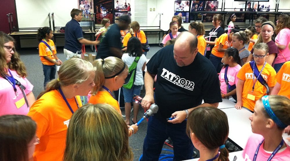 Uponor&rsquo;s Steve Swanson shows a group of girls at TXT 2012 how to make a ProPEX connection with a Milwaukee M12&trade; ProPEX Expansion Tool.