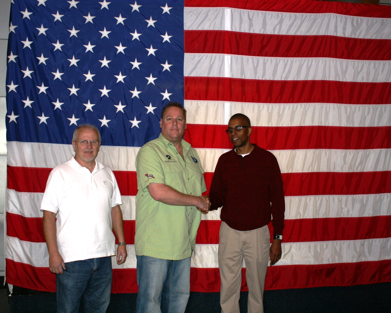John Smith center is thanked for his work at the Challenger Space Center by the facilitys Maynard Mast left and Tim Harris right