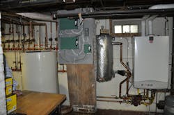 The mechanical room with wallhung boiler at right thermal storage tank at left and zone valve relays in the center The mechanical room with wallhung boiler at right thermal storage tank at left and zone valve relays in the center