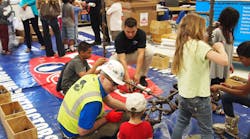 Thomas J. Berlin, a project engineer with Shapiro &amp; Duncan, guides Pinebrook Elementary School students through a hands-on pipefitting discussion. Shapiro &amp; Duncan is in Rockville, Md., and Pinebrook Elementary School is in Aldie, Va.