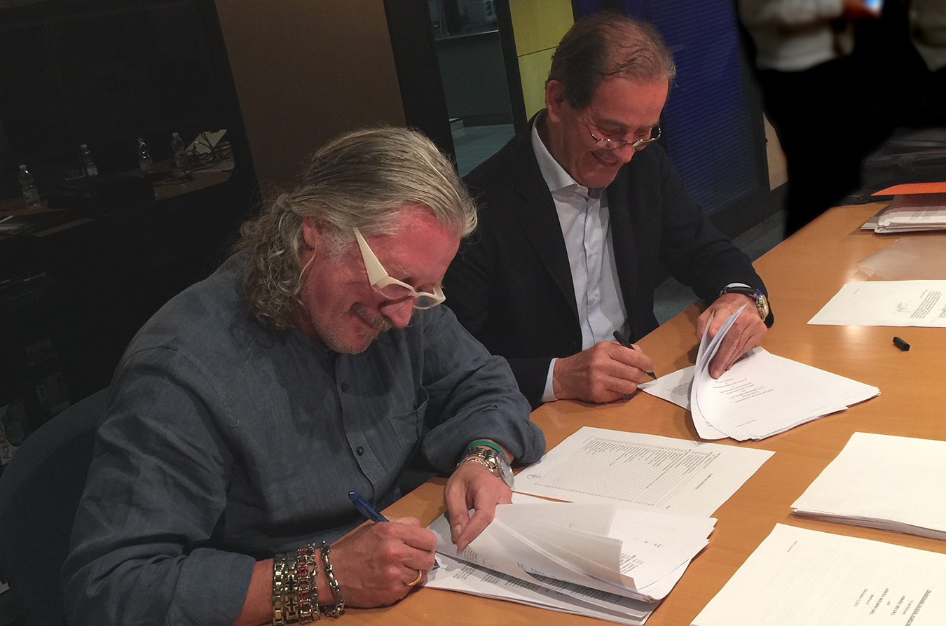 Taco39s John Hazen White Jr and Elio Marioni of Askoll sign sale documents in Dueville Italy