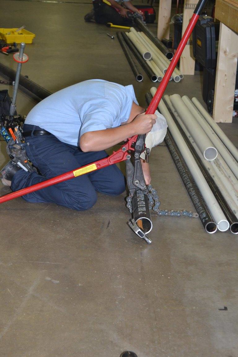 A competitor cuts a section of iron pipe during the SkillsUSA Competition