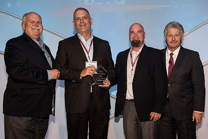 David Weekley left and Bill Justus right vice president of Supply Chain Services at David Weekley Homes present the Partners of Choice Award to Carl Hines national builder sales manager and Tom Stewart regional sales director at Uponor