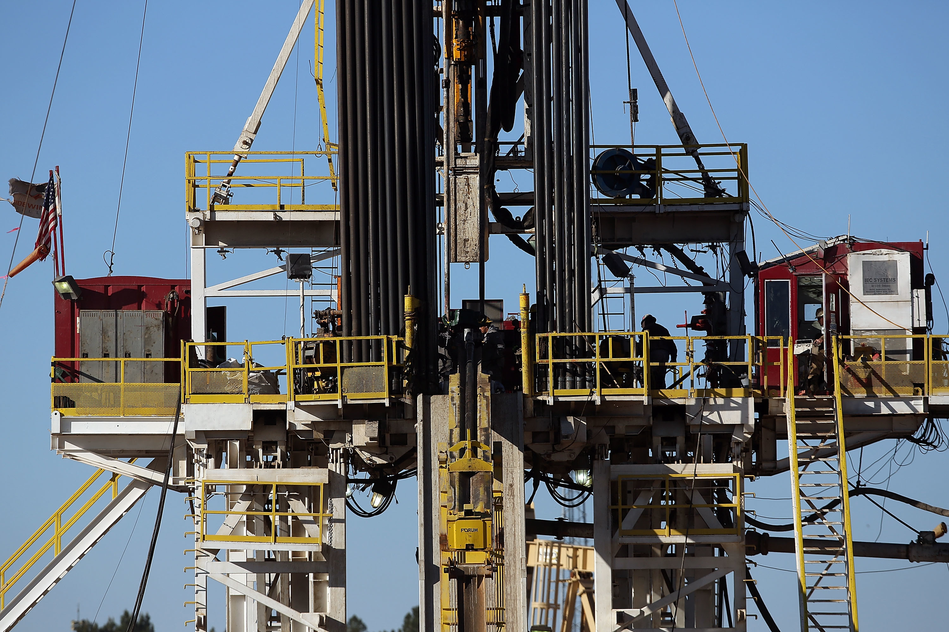 Workers stand on the platform of a fracking rig in the Permian Basin oil field on January 21 2016 in the oil town of Midland Texas