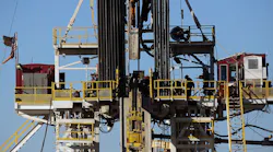 Workers stand on the platform of a fracking rig in the Permian Basin oil field on January 21 2016 in the oil town of Midland Texas