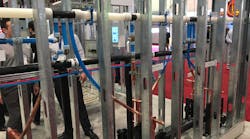 Uponor&rsquo;s booth included a sample of a wall of back-to-back fixture carriers with large diameter PEX and copper stub-outs.