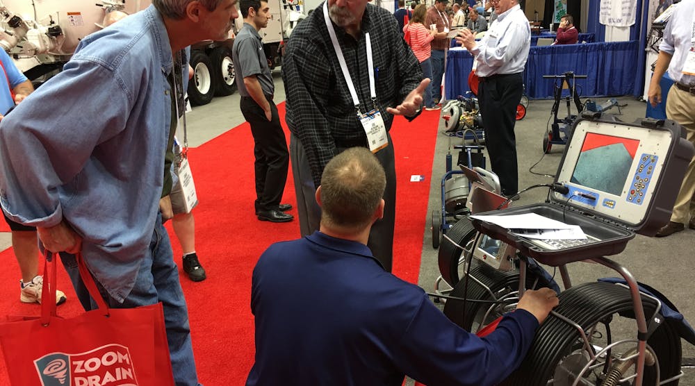 Electric Eel&rsquo;s Joe McCann explains the features of the Cam Pro 2 to two WWETT Show attendees.