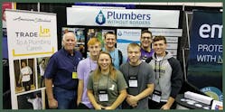 Plumbers Without Borders Vice President Fred Schilling (left) with future HVAC professionals visiting the PWB booth at the 2019 national conference of the Plumbing-Heating-Cooling Contractors in Indianapolis.