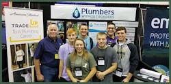 Plumbers Without Borders Vice President Fred Schilling (left) with future HVAC professionals visiting the PWB booth at the 2019 national conference of the Plumbing-Heating-Cooling Contractors in Indianapolis.