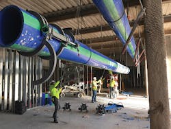 An overhead run of large-diameter Aquatherm pipe being hoisted into place. Note the prototype McElroy Acrobat™ 630 fusion machine’s jaws on the pipe. An overhead run of large-diameter Aquatherm pipe being hoisted into place. Note the prototype McElroy Acrobat™ 630 fusion machine’s jaws on the pipe.