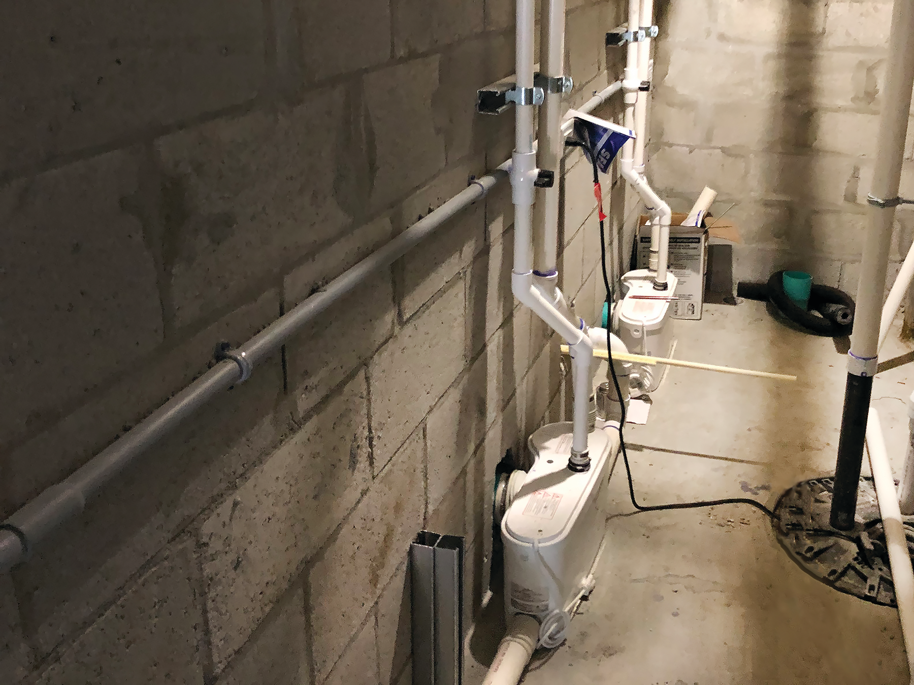 Sanibest Pro grinder units installed to discharge the wastewater from three toilets and a urinal. The two toilets in the women&rsquo;s restroom are each connected to a Sanibest Pro unit.