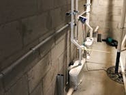 Sanibest Pro grinder units installed to discharge the wastewater from three toilets and a urinal. The two toilets in the women&rsquo;s restroom are each connected to a Sanibest Pro unit.