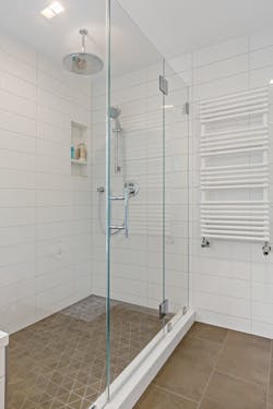 An Oventrop three-way mixing valve prevents higher temperature water meant for the heated towel bar from entering the radiant system. An Oventrop three-way mixing valve prevents higher temperature water meant for the heated towel bar from entering the radiant system.