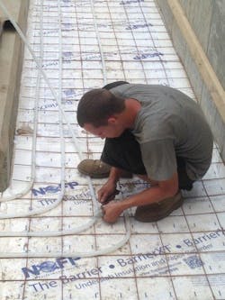 An ACS technician installing Uponor tubing for the snowmelt system. An ACS technician installing Uponor tubing for the snowmelt system.