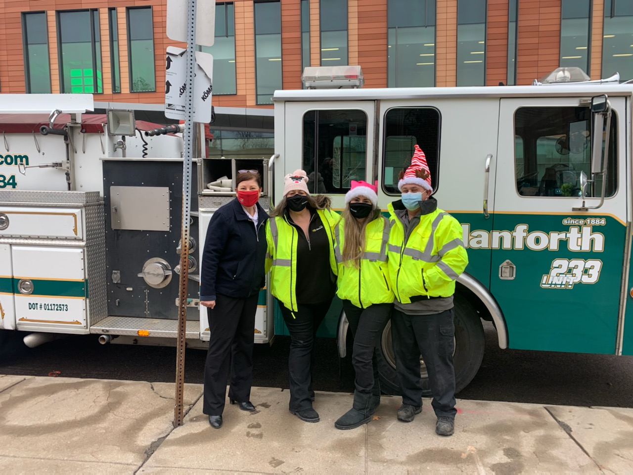 Members of the John W. Danforth team making a delivery to the Salvation Army in the company fire truck.