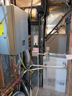 The Johnson Residence mechanical room after the installation of the new combi boiler and air handler. “The heating side works great for us. It is a lot quieter than the system that was installed before,” says Gail Johnson, who added back the condenser coil from the previous setup in the mechanical room to provide cooling. The Johnson Residence mechanical room after the installation of the new combi boiler and air handler. “The heating side works great for us. It is a lot quieter than the system that was installed before,” says Gail Johnson, who added back the condenser coil from the previous setup in the mechanical room to provide cooling.