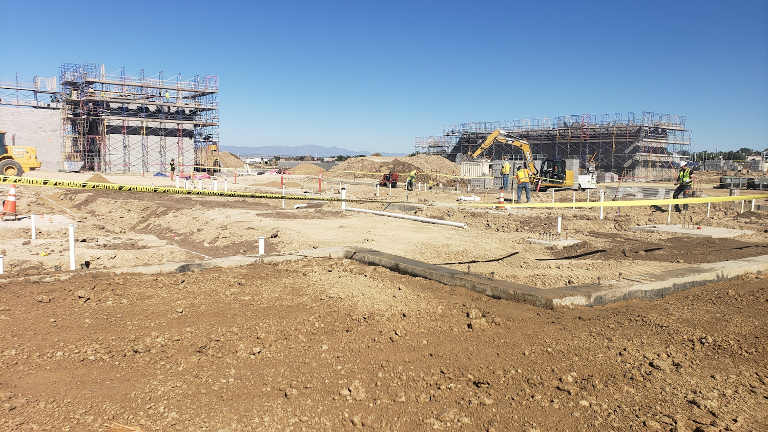 Centennial High School Construction Site | Fall 2021: Early stages of building at the site in Pueblo, Colorado. White pipe is PVC for the school’s underground sanitary system. In the background, block walls for different sections of the school are being erected. The two-story, 185,000-square-foot building broke ground in the spring of 2021 and is slated for completion in 2023.
