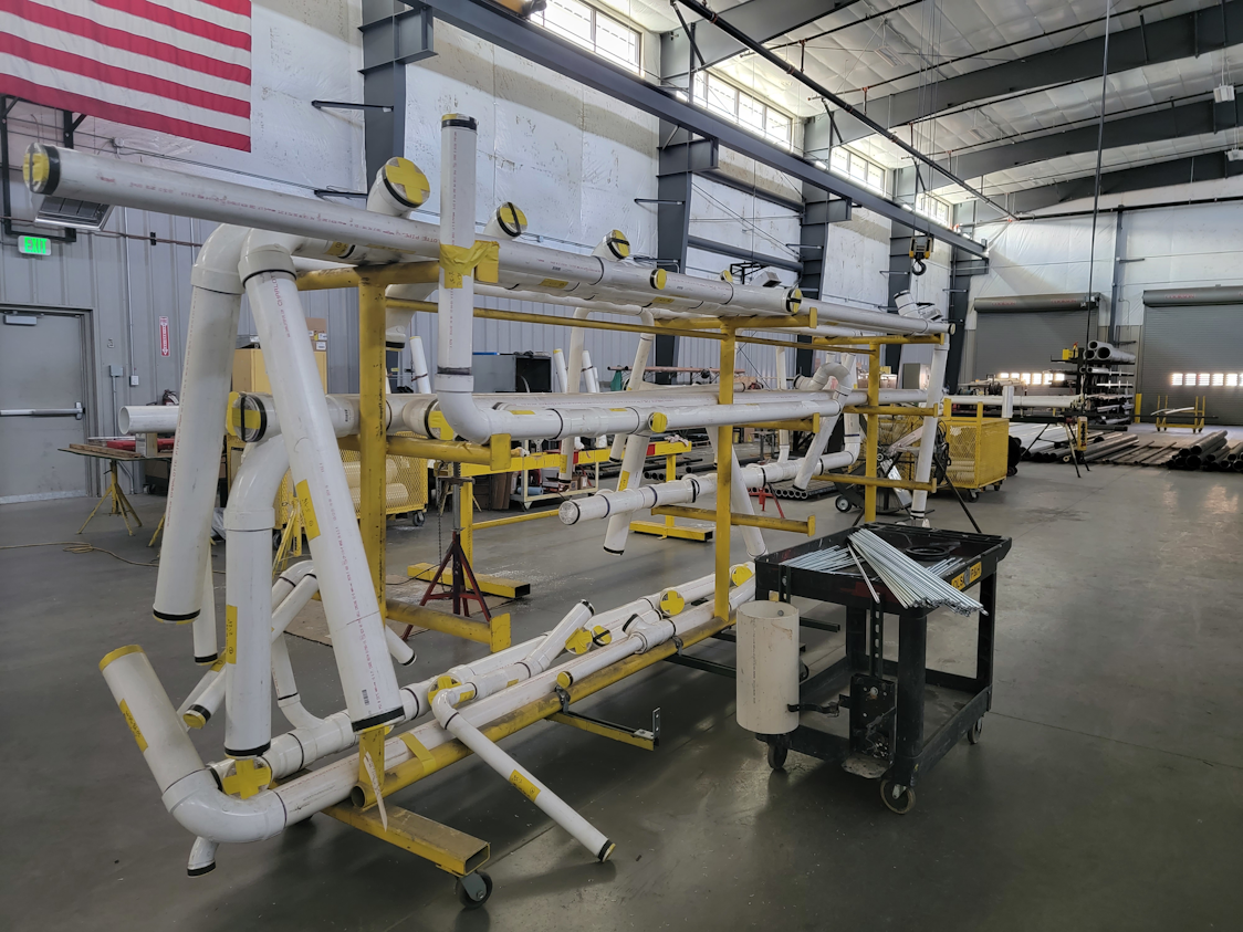 Olson Plumbing & Heating fabrication shop in Colorado Springs: “We felt Centennial would be a really good project for Uponor, given our own emphasis on prefabrication,” says project manager Lana Marsh. Using BIM, Olson can prefabricate 95 percent of the PVC piping installed underground, notes Olson BIM/CAD manager Chris Becker. “Prefabrication makes field installation go substantially faster, a critical necessity for meeting production schedules.” Shown here are 20-foot lengths of PVC, fitted with prefabricated connections, ready for shipment to the job site. Olson Plumbing & Heating fabrication shop in Colorado Springs: “We felt Centennial would be a really good project for Uponor, given our own emphasis on prefabrication,” says project manager Lana Marsh. Using BIM, Olson can prefabricate 95 percent of the PVC piping installed underground, notes Olson BIM/CAD manager Chris Becker. “Prefabrication makes field installation go substantially faster, a critical necessity for meeting production schedules.” Shown here are 20-foot lengths of PVC, fitted with prefabricated connections, ready for shipment to the job site.