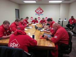A group of technicians training on iPads.