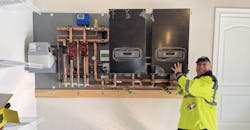 Jason Ridgeway with the prefabbed panel for the system, including HTC boilers, tekmar control and Grundfos circulators. Jason Ridgeway with the prefabbed panel for the system, including HTC boilers, tekmar control and Grundfos circulators.
