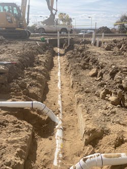 Centennial High School Construction Site | Fall 2021: Underground PVC drainage pipe &mdash; 6-inch trunks with 2-, 3-, and 4-inch branches &mdash; is installed in 20-foot, premade sections into the graded ditch, so that the lengths can be quickly connected. Olson installers are given spool &ldquo;maps&rdquo; showing how to assemble the various prefabricated PVC sections, which accelerates field installation. &ldquo;Back in the day, we had to measure each piece, cut them in the field and then assemble them in the dirt,&rdquo; says Olson Plumbing &amp; Heating BIM/CAD manager Chris Becker. &ldquo;It was a lot more cumbersome process.&rdquo;
