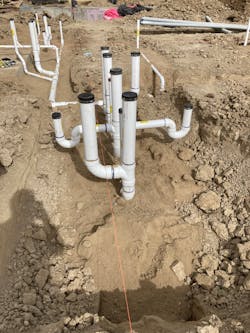 Centennial High School Construction Site | Fall 2021: Prefabricated, PVC pipe configuration for a school restroom with a toilet, two floor drains and connections for sinks on the opposite side. Creating multiple, complex pipe configurations like this under the highly controlled conditions of a prefab shop is a huge improvement over building them from scratch in the field. Centennial High School Construction Site | Fall 2021: Prefabricated, PVC pipe configuration for a school restroom with a toilet, two floor drains and connections for sinks on the opposite side. Creating multiple, complex pipe configurations like this under the highly controlled conditions of a prefab shop is a huge improvement over building them from scratch in the field.