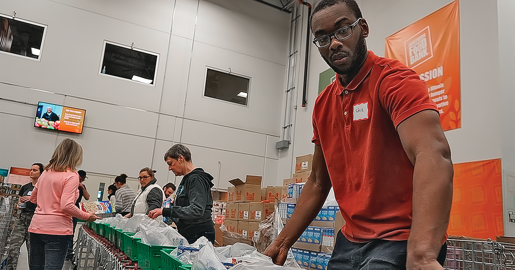 An SFA Saniflo volunteer helps pack meals for delivery.