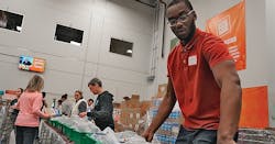 An SFA Saniflo volunteer helps pack meals for delivery. An SFA Saniflo volunteer helps pack meals for delivery.