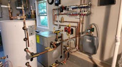 The new mechanical room. Left to right are a 42-gal. Viessmann Vito DHW tank, a Viessmann Vito Rond cast iron boiler, a Grundfos circulator and (on the wall) a Zilmet Model ZFT expansion tank. Above, on the wall, is a Viega Model 12152 Enhanced Mixing Station (with another Grundfos circulator on the left-hand side). The new mechanical room. Left to right are a 42-gal. Viessmann Vito DHW tank, a Viessmann Vito Rond cast iron boiler, a Grundfos circulator and (on the wall) a Zilmet Model ZFT expansion tank. Above, on the wall, is a Viega Model 12152 Enhanced Mixing Station (with another Grundfos circulator on the left-hand side).
