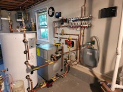 The new mechanical room. Left to right are a 42-gal. Viessmann Vito DHW tank, a Viessmann Vito Rond cast iron boiler, a Grundfos circulator and (on the wall) a Zilmet Model ZFT expansion tank. Above, on the wall, is a Viega Model 12152 Enhanced Mixing Station (with another Grundfos circulator on the left-hand side). The new mechanical room. Left to right are a 42-gal. Viessmann Vito DHW tank, a Viessmann Vito Rond cast iron boiler, a Grundfos circulator and (on the wall) a Zilmet Model ZFT expansion tank. Above, on the wall, is a Viega Model 12152 Enhanced Mixing Station (with another Grundfos circulator on the left-hand side).