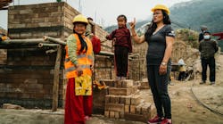 New homeowner Sabita T. taking a break on her job site with NIVAS Program Coordinator in Nuwakot, Nepal.