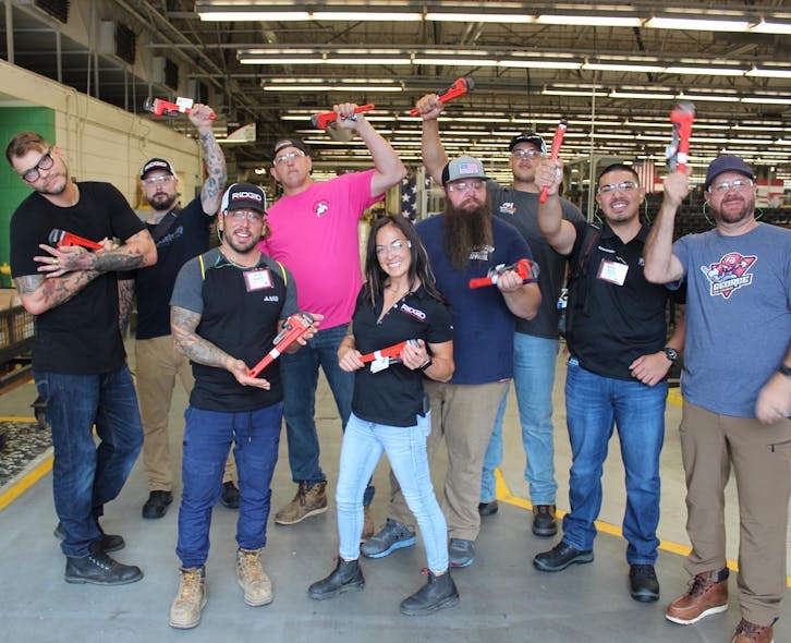 Experience Trip winners at the end of the factory tour, each holding their customized wrenches.