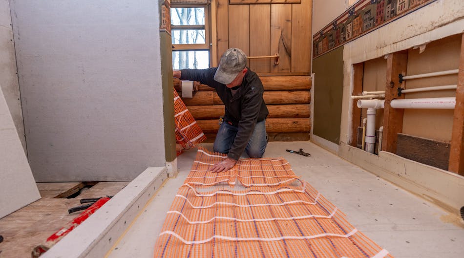 An installer laying out SunTouch radiant mats.