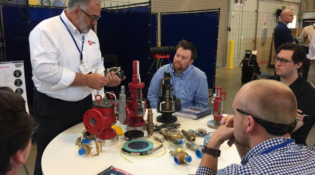 A presenter discuses the function of various valve components at a past Valve Basics Seminar and Petting Zoo.