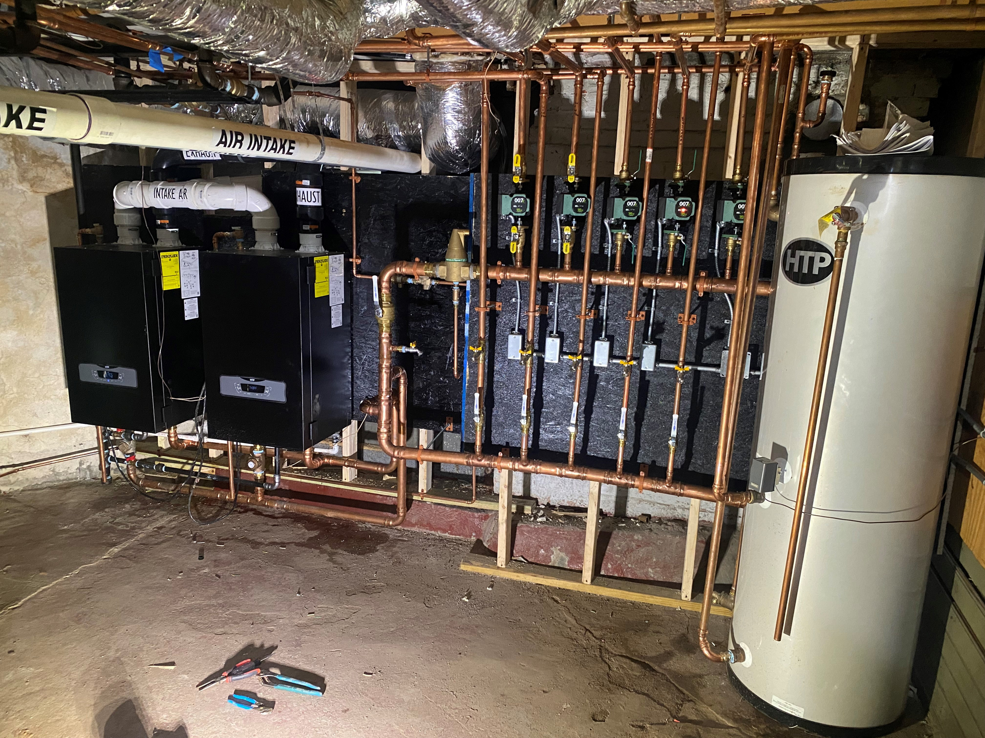 The mechanical room a the Massachusetts home with HTP boilers and storage tank, and Taco circulators.