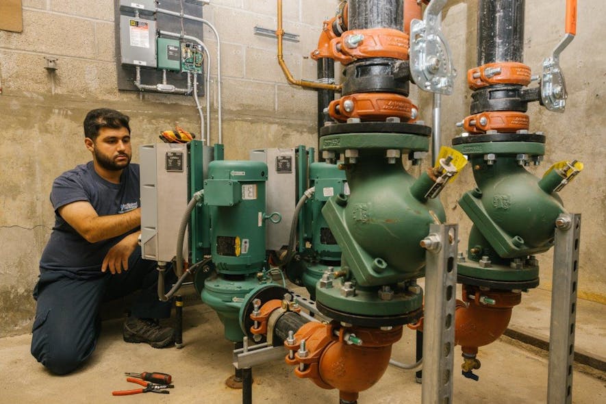 A NETE technician checks on the new Taco SKV vertical, in-line self-sensing pumps at the Greenwich Catholic School.