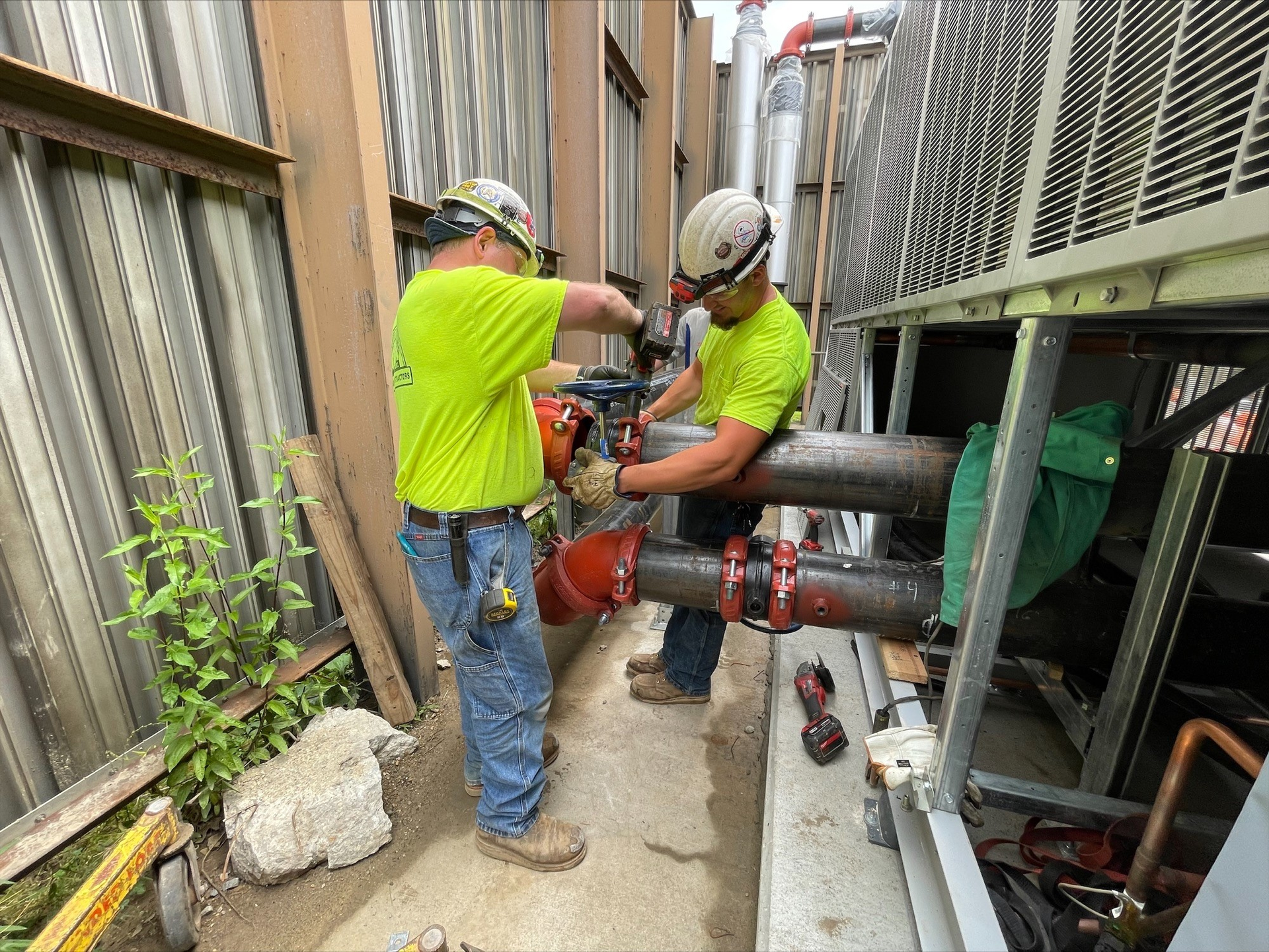 Two General Piping technicians install a valve.