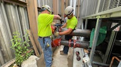 Two General Piping technicians install a valve. Two General Piping technicians install a valve.
