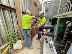 Two General Piping technicians install a valve. Two General Piping technicians install a valve.