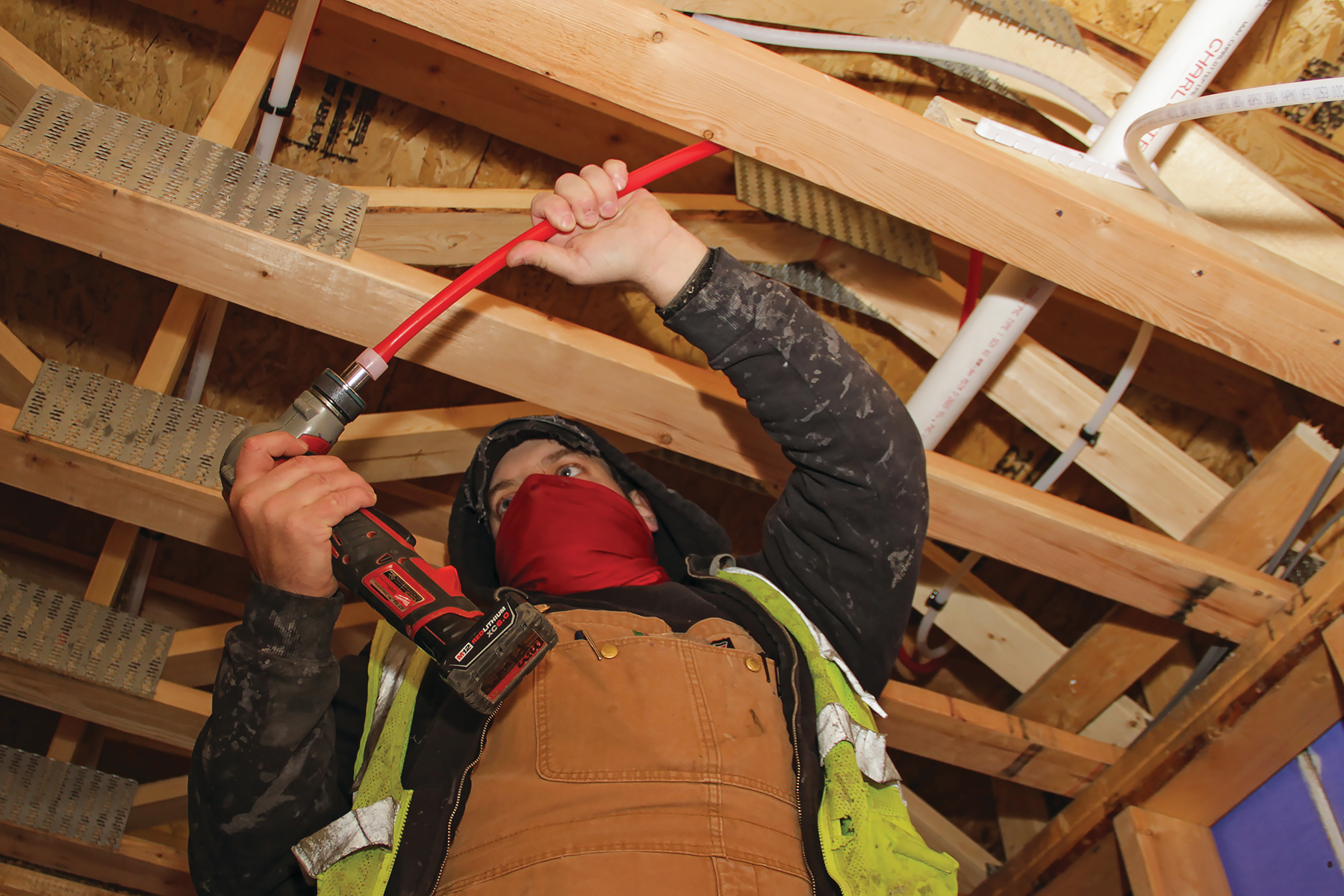Major Mechanical installer expanding PEX pipe with the Expander Tool before inserting a fitting. The flexibility of PEX reduces the number of connections, saving labor expense while also eliminating potential leak points.
