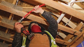 Major Mechanical installer expanding PEX pipe with the Expander Tool before inserting a fitting. The flexibility of PEX reduces the number of connections, saving labor expense while also eliminating potential leak points.