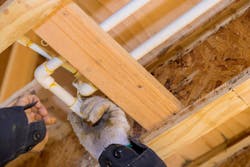 A technician fitting pieces of CPVC pipe together with solvent welds. A technician fitting pieces of CPVC pipe together with solvent welds.