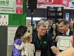 Dan Holohan (at right) presents the award to Hazen III's wife, Katelyn, and their daughter, Madison Marie at the 2023 AHR Expo. Dan Holohan (at right) presents the award to Hazen III's wife, Katelyn, and their daughter, Madison Marie at the 2023 AHR Expo.