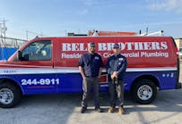 Two company technicians in front of a Bell Brothers service van.