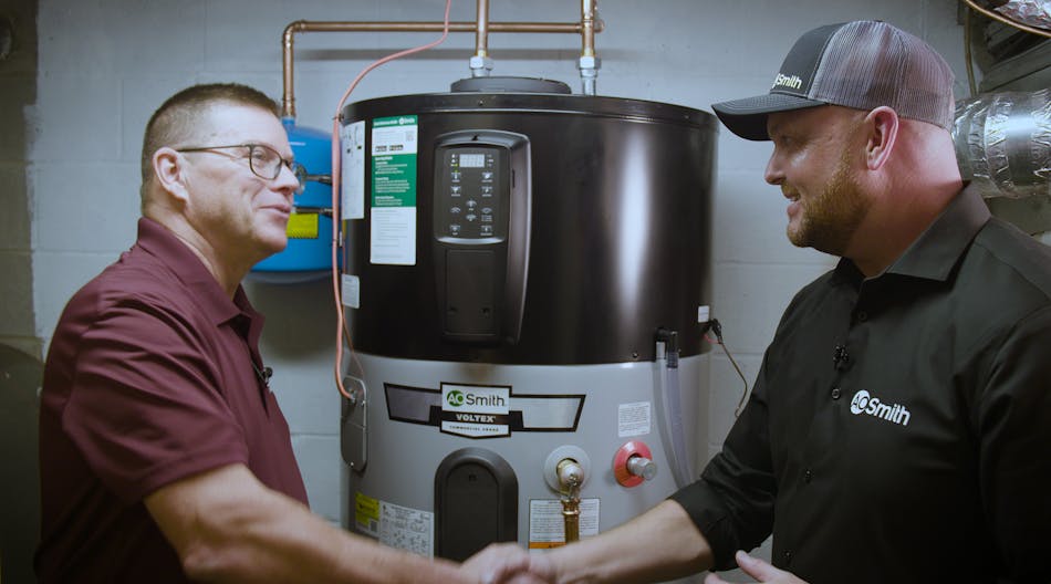 Gerry Winset of A.O. Smith (right) shakes hands with Carl (left), a tech working with W. L. Staton Plumbing, Cooling &amp; Heating, in front of a Voltex hybrid electric heat pump water heater.
