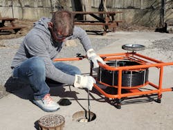 A service technician cleans a drain. A service technician cleans a drain.